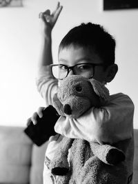 Portrait of boy holding toy at home