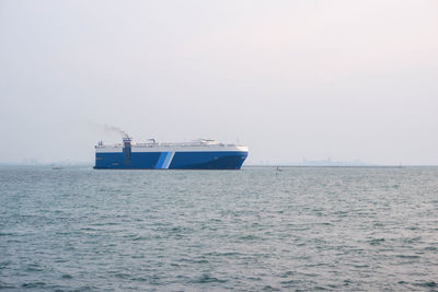 Boat sailing in sea against clear sky