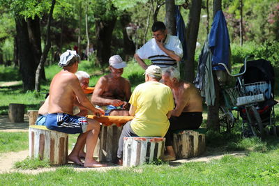 Friends sitting on field in forest