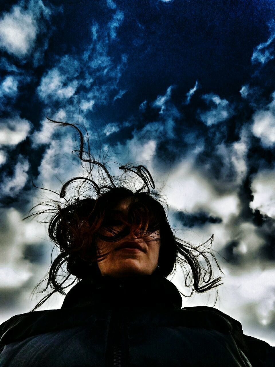 headshot, sky, young adult, person, low angle view, cloud - sky, lifestyles, portrait, looking at camera, head and shoulders, leisure activity, young women, bare tree, front view, cloud, outdoors, human face, cloudy