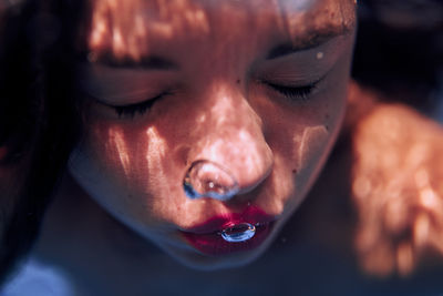 Close-up underwater, of young woman.  the face and skin of a girl, swims in the pool, bubbles. water