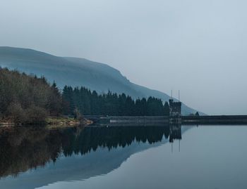 Scenic view of lake by trees against clear sky