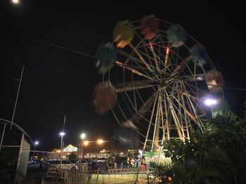 Low angle view of illuminated ferris wheel against sky at night