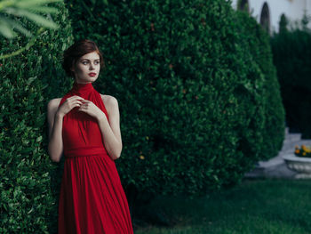 Young woman standing by plants at park