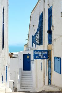 Text on wall by sea against blue sky