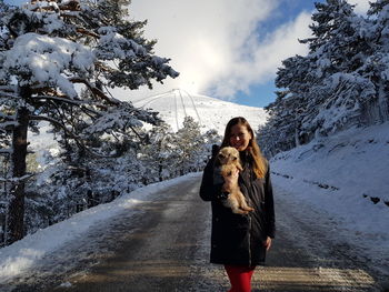 Full length of woman standing on snow covered tree