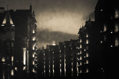 Illuminated city against sky at night