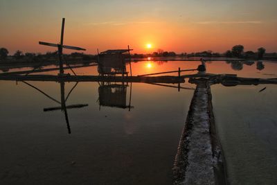 Silhouette of wooden post against sky during sunset