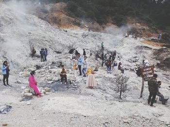 Group of people standing on land against mountain