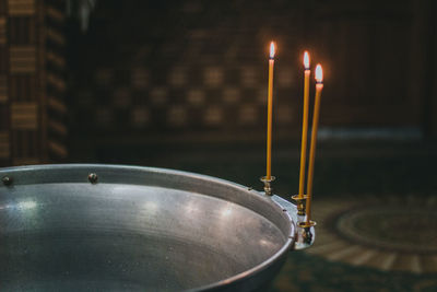 Close-up of illuminated candles at temple