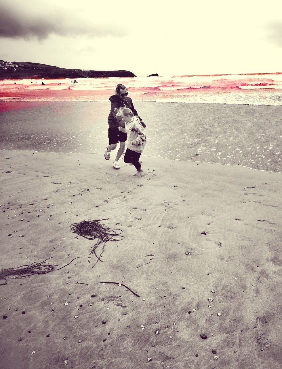 REAR VIEW OF WOMAN ON BEACH DURING WINTER