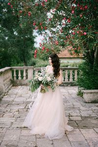 Rear view of woman with umbrella against plants