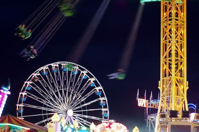Low angle view of illuminated ferris wheel against sky at night