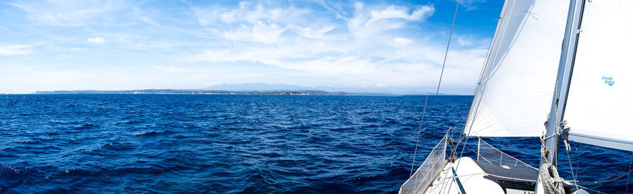 Boat in sea against cloudy sky