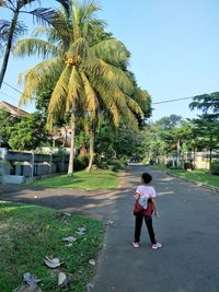 Rear view of woman walking on footpath