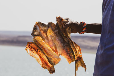 Fisherman holding the dried fish from lake turkana