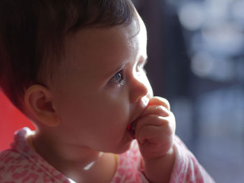 Baby with blue eyes eating piece of bread.