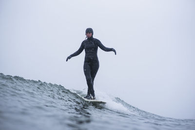 Full length of man standing in sea against clear sky