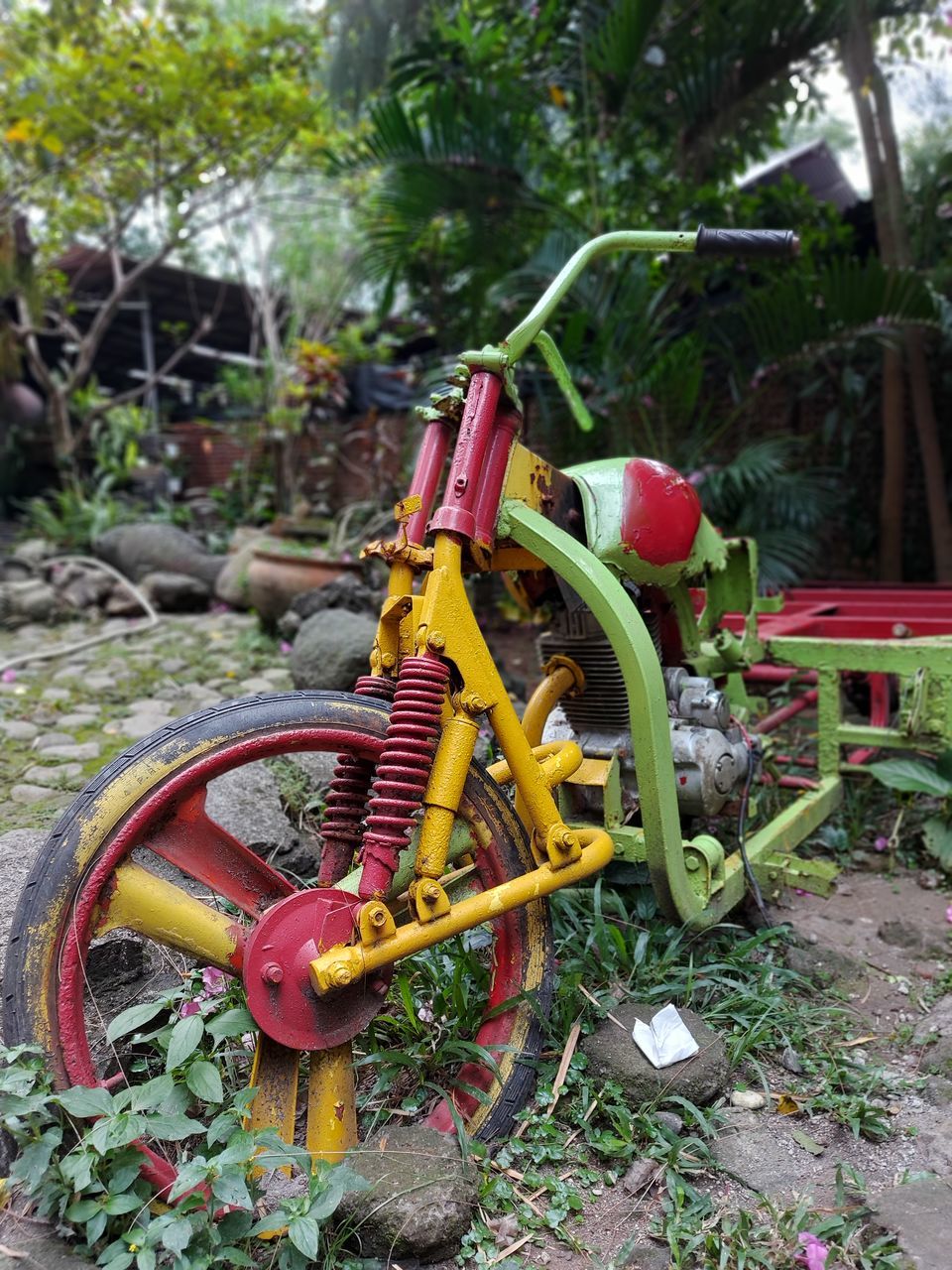 CLOSE-UP OF ABANDONED BICYCLE IN GARDEN