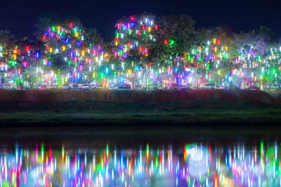 Colorful illuminated rainbow over water at night