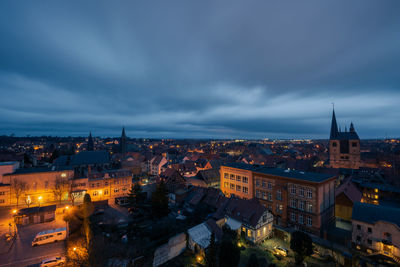 High angle view of illuminated city against cloudy sky