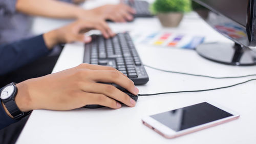 Midsection of man using laptop on table