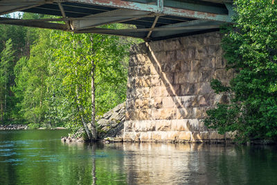 Bridge over river against trees