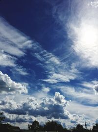 Low angle view of trees against blue sky