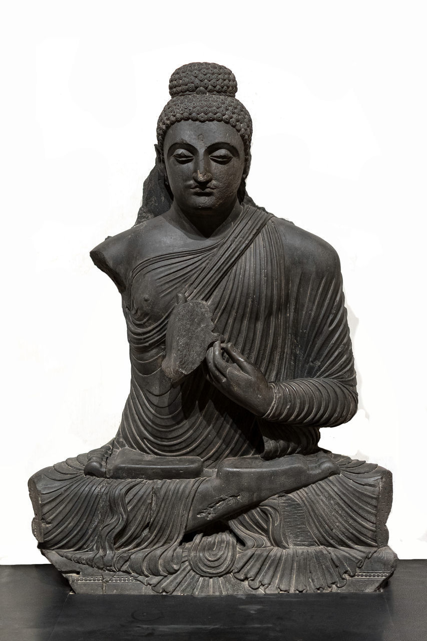 STATUE OF BUDDHA AGAINST WHITE BACKGROUND