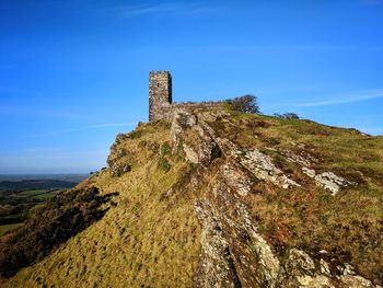 Low angle view of chapel on hill against blue sky