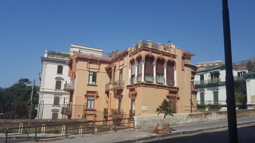 Street by building against clear blue sky