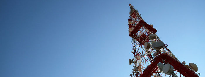 Low angle view of crane against clear blue sky