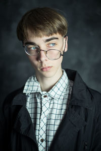 Portrait of young man against gray wall