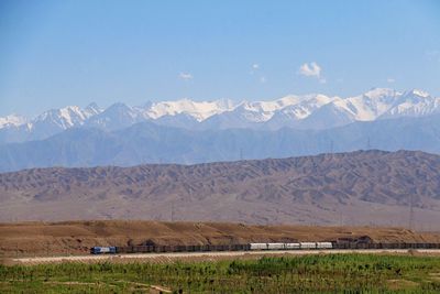 Scenic view of field and mountains against sky