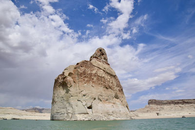 Rock formation by lake powell against sky