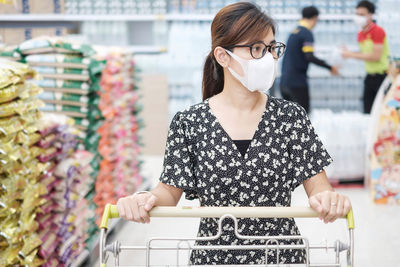 Woman looking away while standing at store