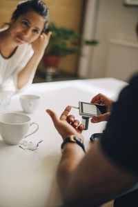 Woman using smart phone while sitting on table