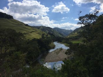 Scenic view of river amidst mountains against sky