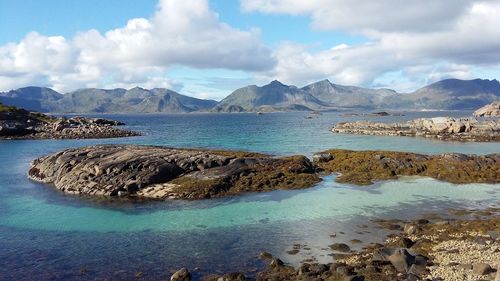 Scenic view of sea and mountains against sky