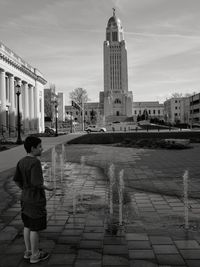 Boy standing against nebraska state capitol building 