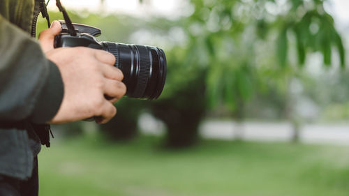 Midsection of man holding camera