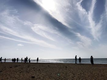 People at beach against sky