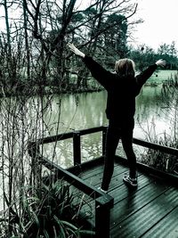 Full length rear view of man standing by lake