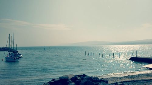 Boats sailing in sea against sky