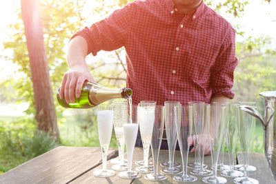 Close-up of person pouring champagne