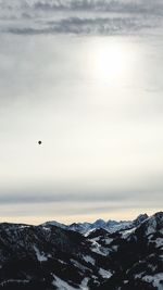 Scenic view of snowcapped mountains against cloudy sky