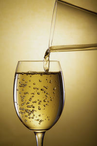 Pour white wine from a carafe into a wine glass