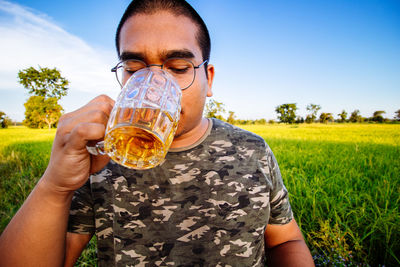 Portrait of young man drinking beer glass