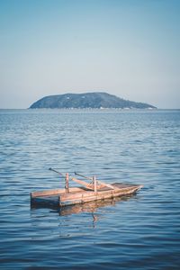 Ship floating on sea against clear sky
