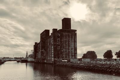 Building by river against sky